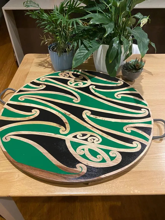 Green kōwhaiwhai platter by Hori.Inc on a table